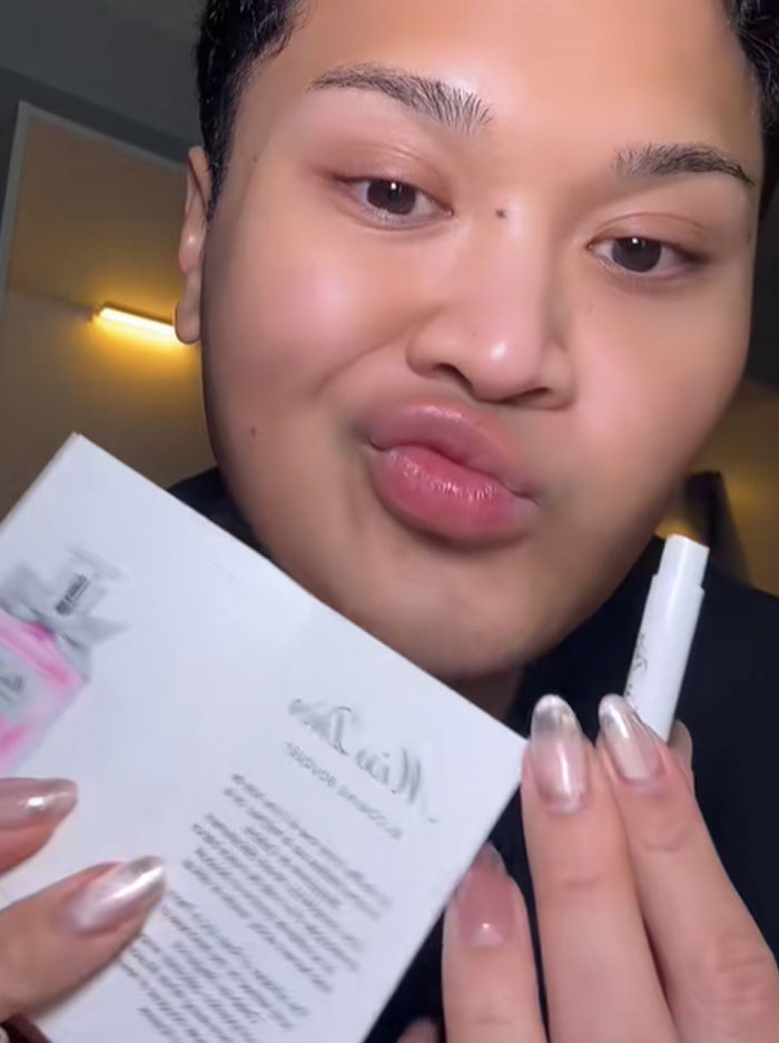 Person holding Dior advent calendar items with an unimpressed expression, highlighting Dior advent calendar reaction