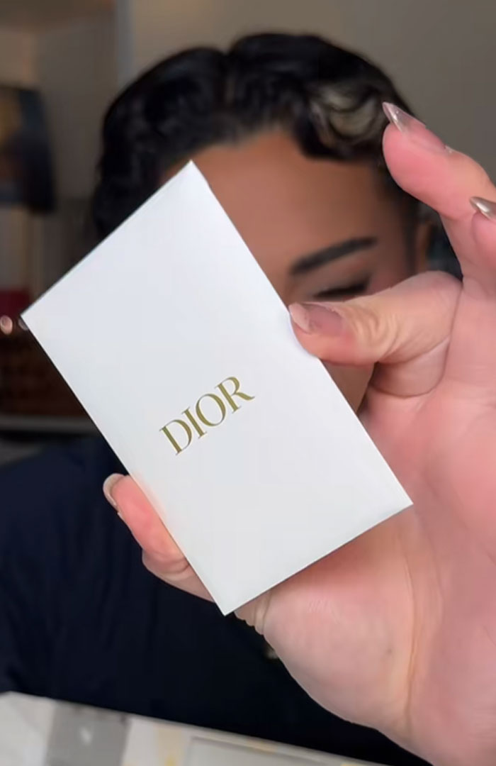 Person holding a white Dior advent calendar box with gold lettering, highlighting the luxury holiday product.