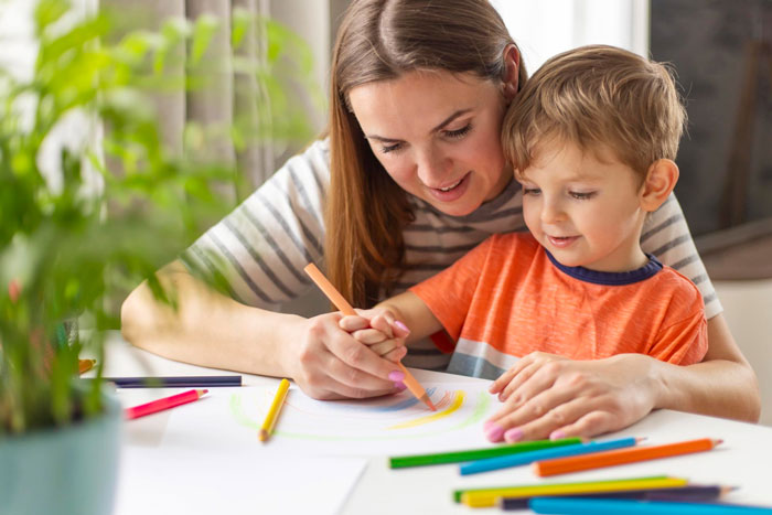 Mother and child drawing together at a table, showing loving support in parenting despite ungrateful husband challenges.