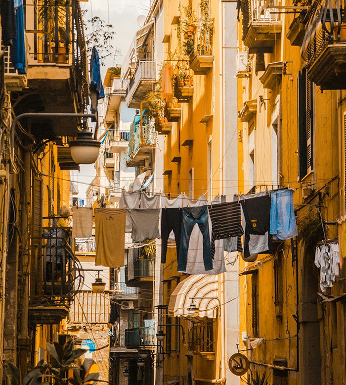 Narrow urban street with clothes hanging on lines, highlighting places solo female travelers do not recommend.
