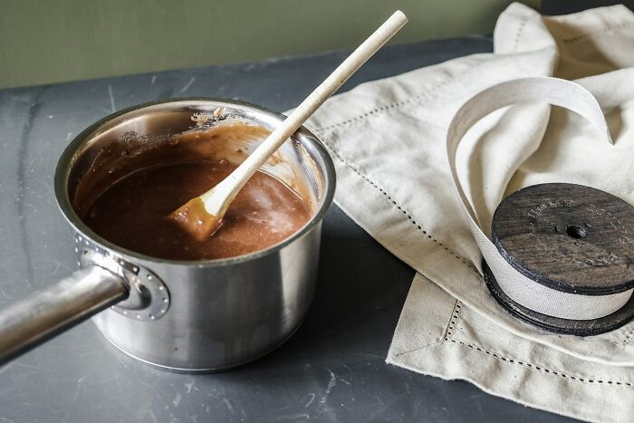 Saucepan with chocolate mixture being stirred on a counter, illustrating childhood habits that seem unusual or non-normal.