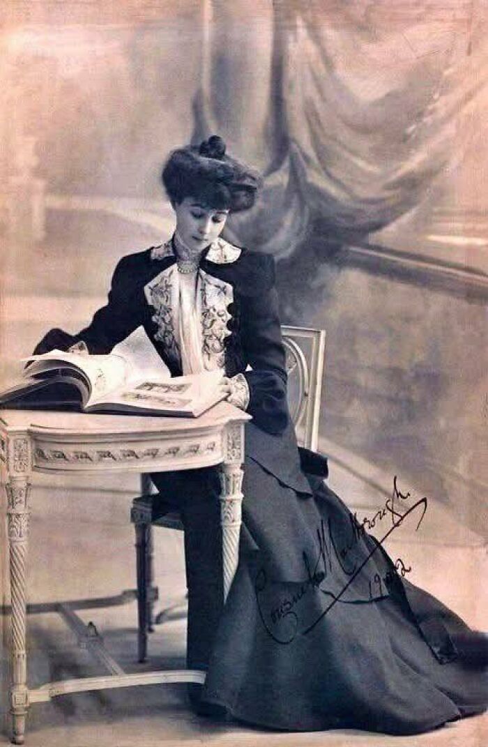 Victorian-Edwardian pictures of a woman in period dress sitting at an ornate table, reading an open book indoors.