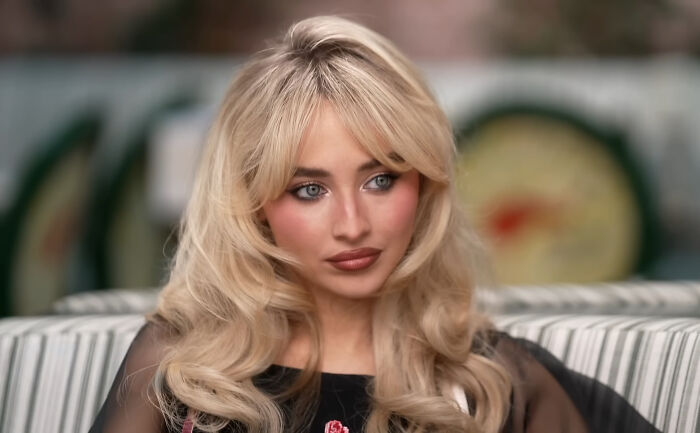 Young woman with blonde hair and blue eyes seated, representing nepo babies sharing insider experiences and shocking stories.