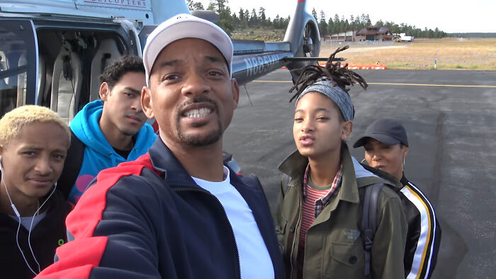 Group of nepo babies gathered near a helicopter, sharing insider experiences that surprise regular people outdoors.