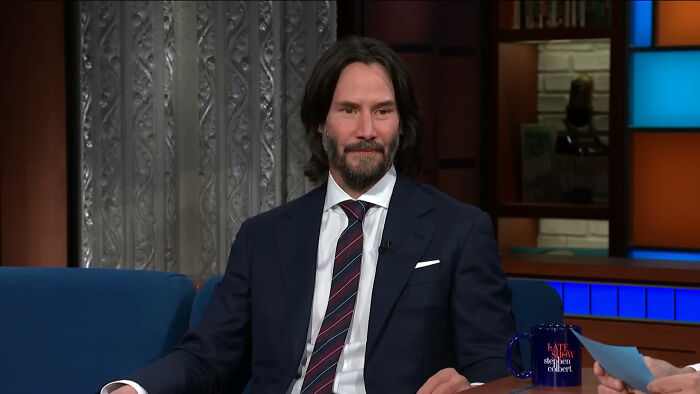 Actor Keanu Reeves in a talk show setting discussing nepo babies and insider experiences in the entertainment industry.