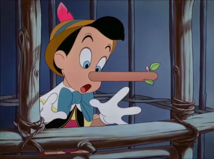 Pinocchio with an extended nose behind wooden bars, illustrating signs child never loved properly and emotional distress.