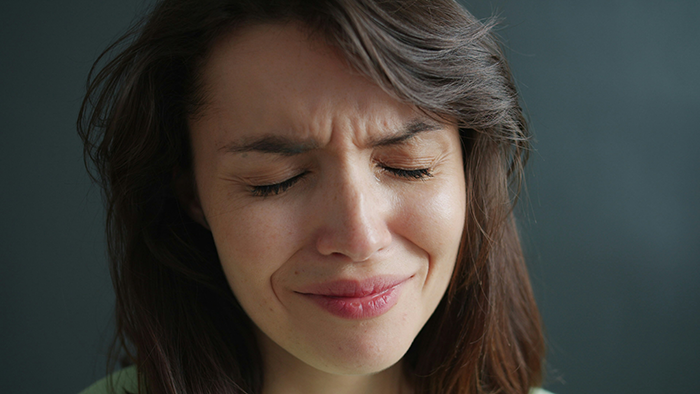 Close-up of a distressed woman fighting for her life in hospital, showing emotional pain and struggle indoors.