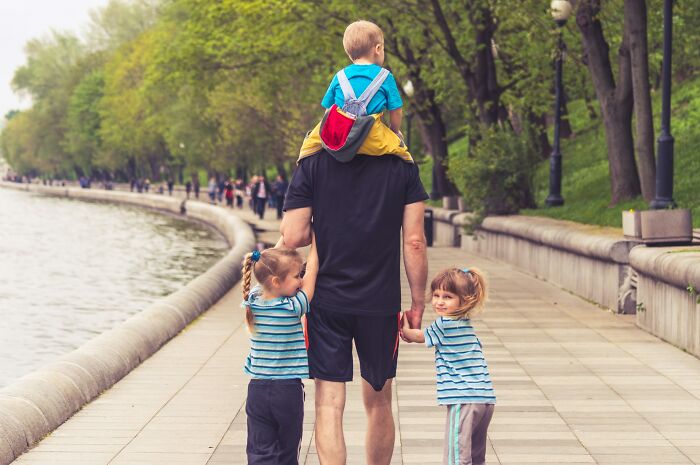 Father walking with kids by the river, showing funny moments kids did something weird passed down from their parents.