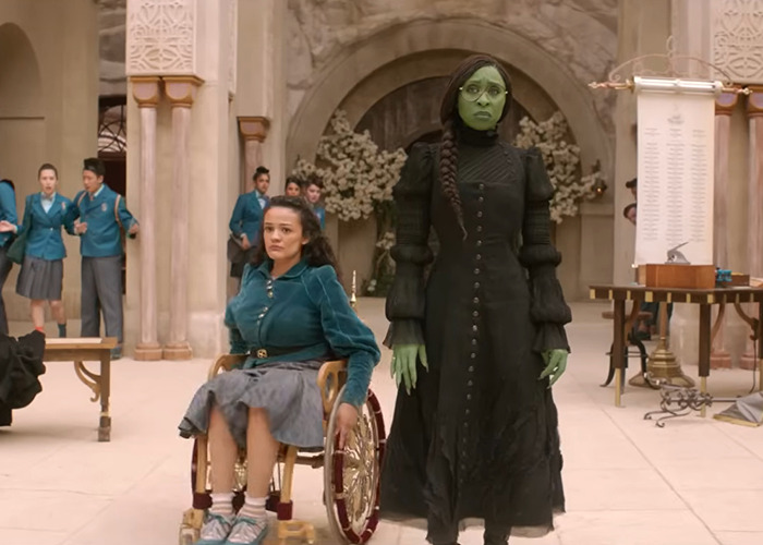 Wicked cast members in costume during a scene, highlighting a discussion on disability inclusion controversy.