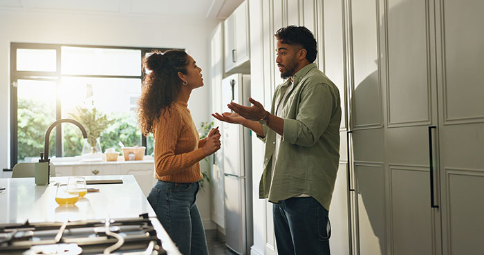 Couple having a tense conversation in the kitchen about a guy secretly giving his sister a key to girlfriend&rsquo;s house.