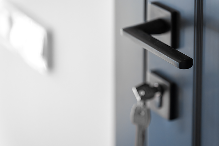 Close-up of a locked office door with key in the lock, hinting at a pregnant wife&rsquo;s growing suspicion and defensive behavior.