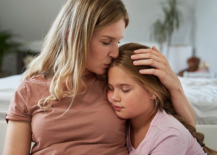 Woman comforting child at home, reflecting strength and independence without a jobless partner burdening her life.