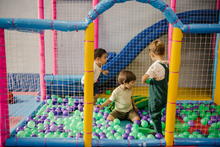 Three children playing in a colorful ball pit at a private party, reflecting entitled mother denied entrance controversy. Three children playing in a colorful ball pit at a private party, reflecting entitled mother denied entrance controversy.