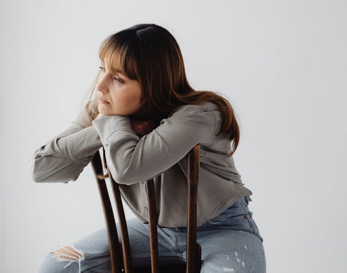 Entitled mother looking upset and frustrated after being denied entrance at a private party, sitting on a chair. Entitled mother looking upset and frustrated after being denied entrance at a private party, sitting on a chair.