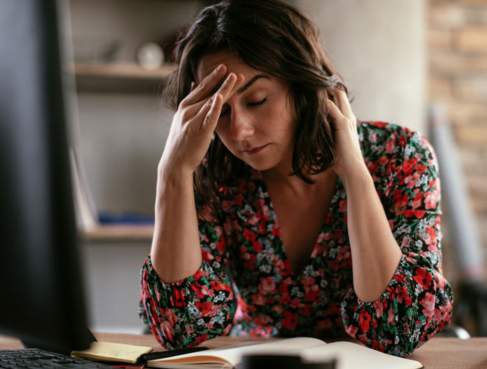 Woman feeling stressed and overwhelmed while asking for a break from hosting a traditional family Thanksgiving.