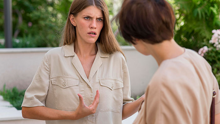A woman refusing her homeless sister-in-law to move in, showing a tense and emotional conversation outdoors.