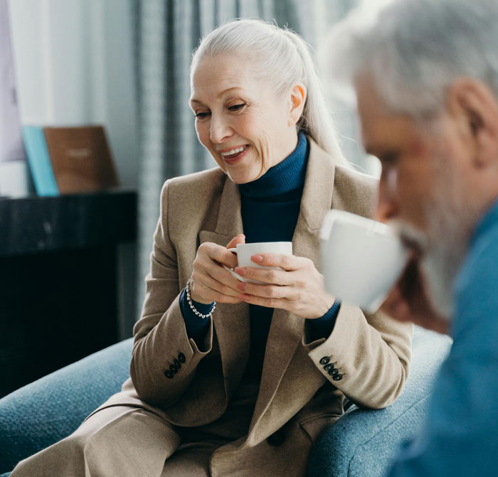 Older couple enjoying coffee together indoors, illustrating grandparents combine birthday and Christmas gift concept.
