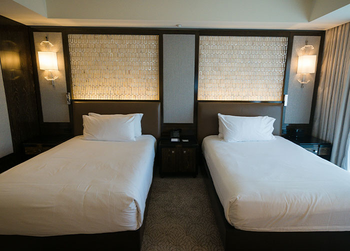 Hotel room with two beds and bedside lamps, illustrating worst night's sleep due to the place they were in environment.