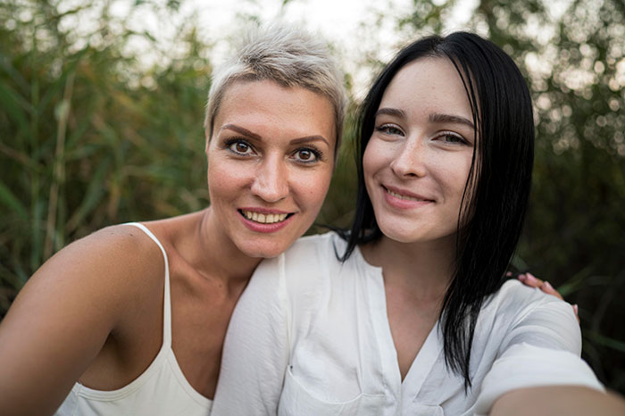 Two women smiling outside, symbolizing late half-sis lies and family support with medical bills.