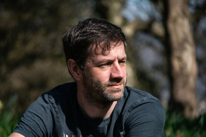 Man outdoors in natural light looking thoughtful, representing people who regret having kids sharing why.