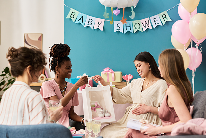Woman at baby shower showing engagement ring while holding baby gift, cousin's family accusing her of stealing spotlight.