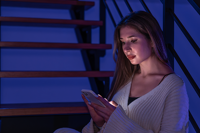 Young woman sitting on stairs at night, focused on her phone, reflecting on borrowing a car for one hour then keeping it days. Young woman sitting on stairs at night, focused on her phone, reflecting on borrowing a car for one hour then keeping it days.