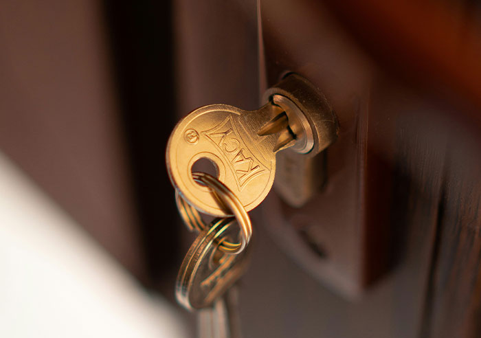 Key with KAG engraving inserted in a door lock, symbolizing insights from people who have worked in a zoo.