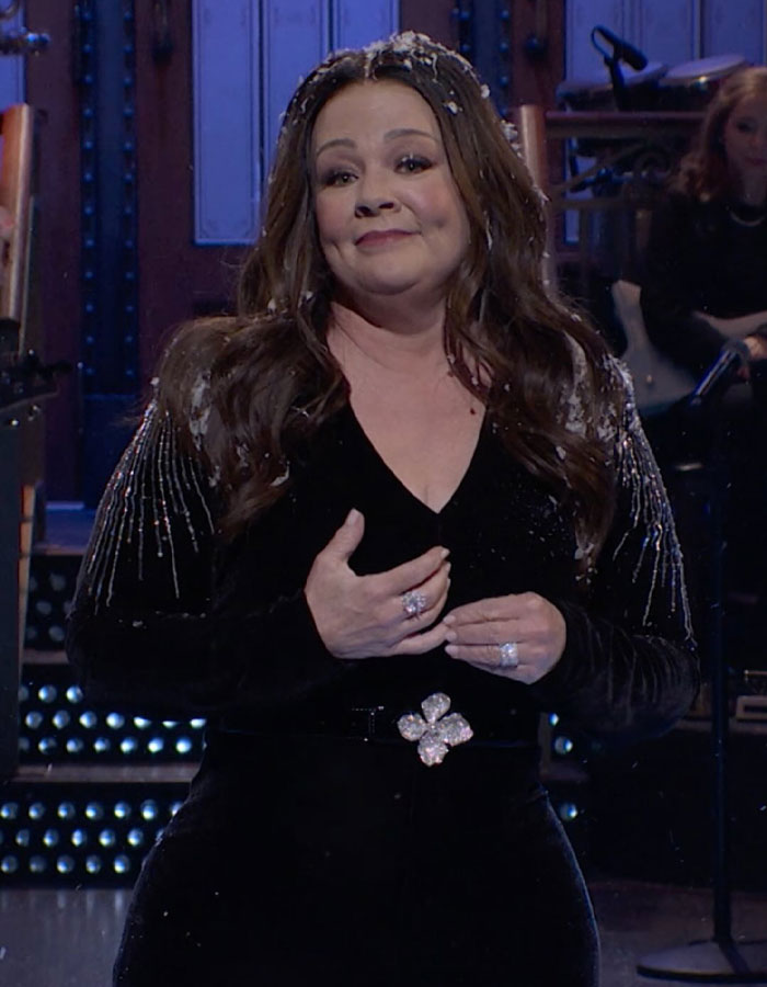 Melissa McCarthy in a black dress on SNL stage, showcasing her jaw-dropping 95-pound weight loss transformation.