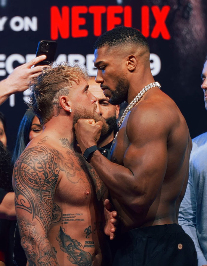 Jake Paul and opponent in intense face-off during boxing weigh-in, highlighting Jake Paul's broken jaw story.