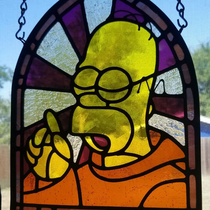 Stained glass art of a pop culture icon Homer Simpson in vibrant colors and detailed design.