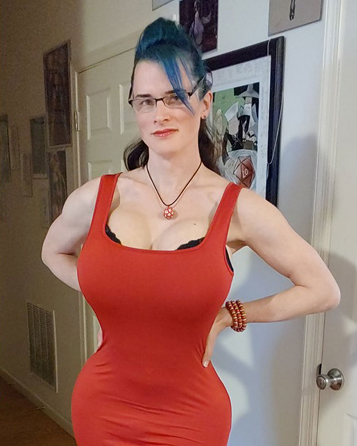 High school teacher in a red costume posing indoors, sparking controversy among parents over outfit choice.