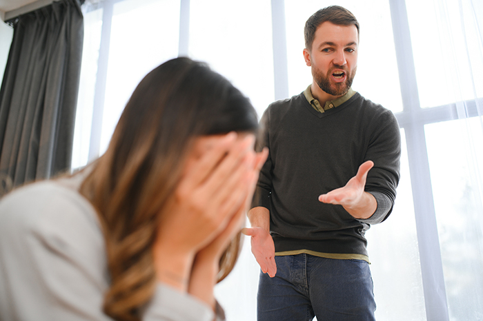 Man expressing frustration while wife covers her face, illustrating marriage falling apart due to ATM machine treatment.