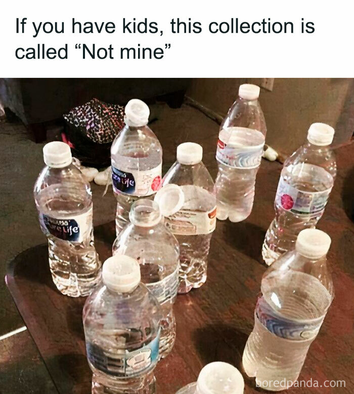 Several half-full water bottles on a table representing relatable memes for parents going through it.
