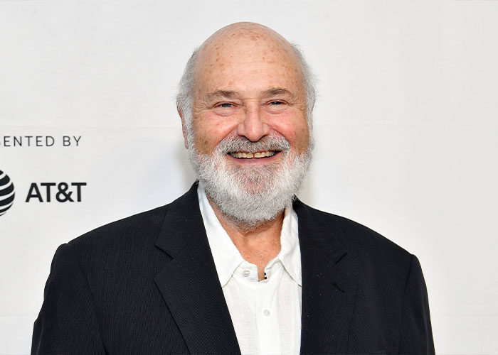 Rob Reiner smiling in a black jacket and white shirt at a media event, related to Trump controversy over TDS claims. Rob Reiner smiling in a black jacket and white shirt at a media event, related to Trump controversy over TDS claims.
