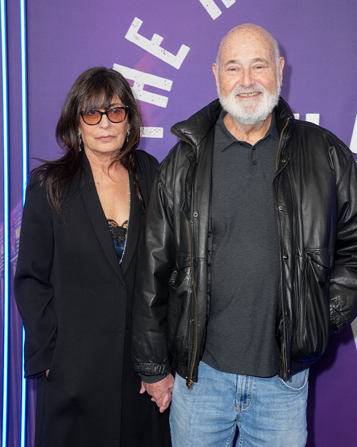 Rob Reiner at public event wearing black leather jacket beside woman in black coat with sunglasses. Rob Reiner at public event wearing black leather jacket beside woman in black coat with sunglasses.