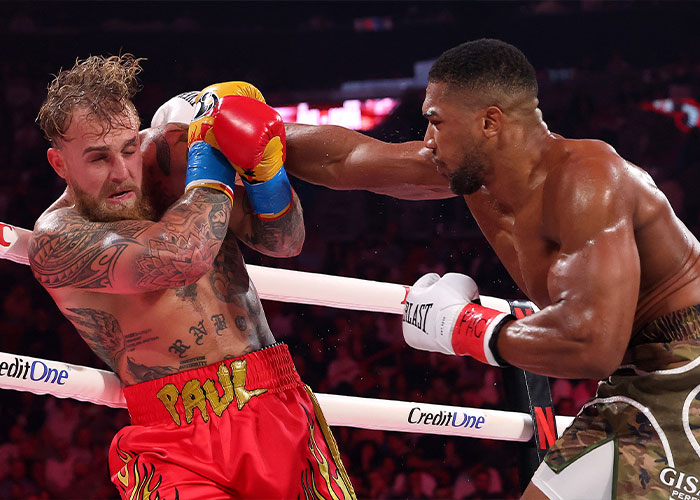 Jake Paul taking a punch in the boxing ring, highlighting his broken jaw as the internet's latest punchline.