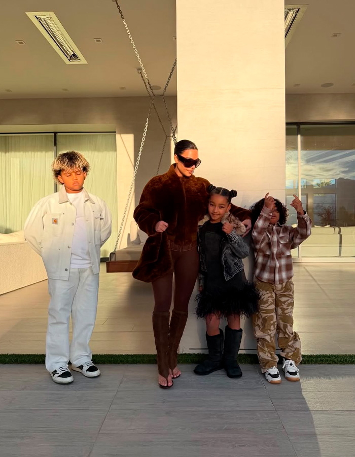 Kim Kardashian with her kids posing outdoors, fans discuss Christmas card failure and kids home life concerns.