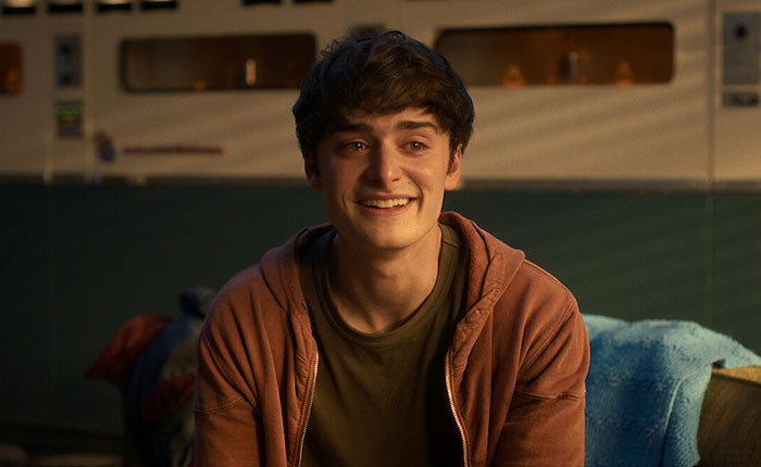 Young man in casual hoodie smiling indoors, representing Stranger Things 5 characters in a scene from the series. Young man in casual hoodie smiling indoors, representing Stranger Things 5 characters in a scene from the series.