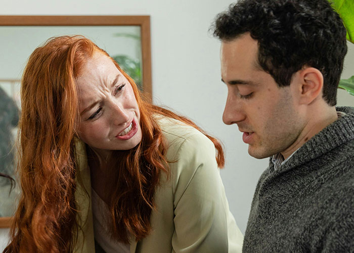 A woman confronting a man looking down, depicting intense emotions related to insane ex stories shared by people.