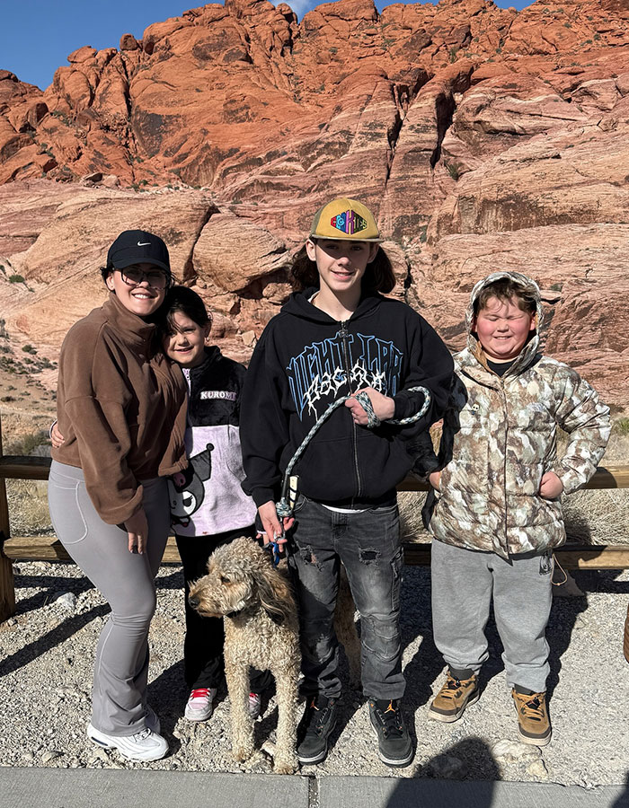 Jenelle Evans with three children and a dog outdoors in casual clothes against a rocky desert background. Jenelle Evans with three children and a dog outdoors in casual clothes against a rocky desert background.
