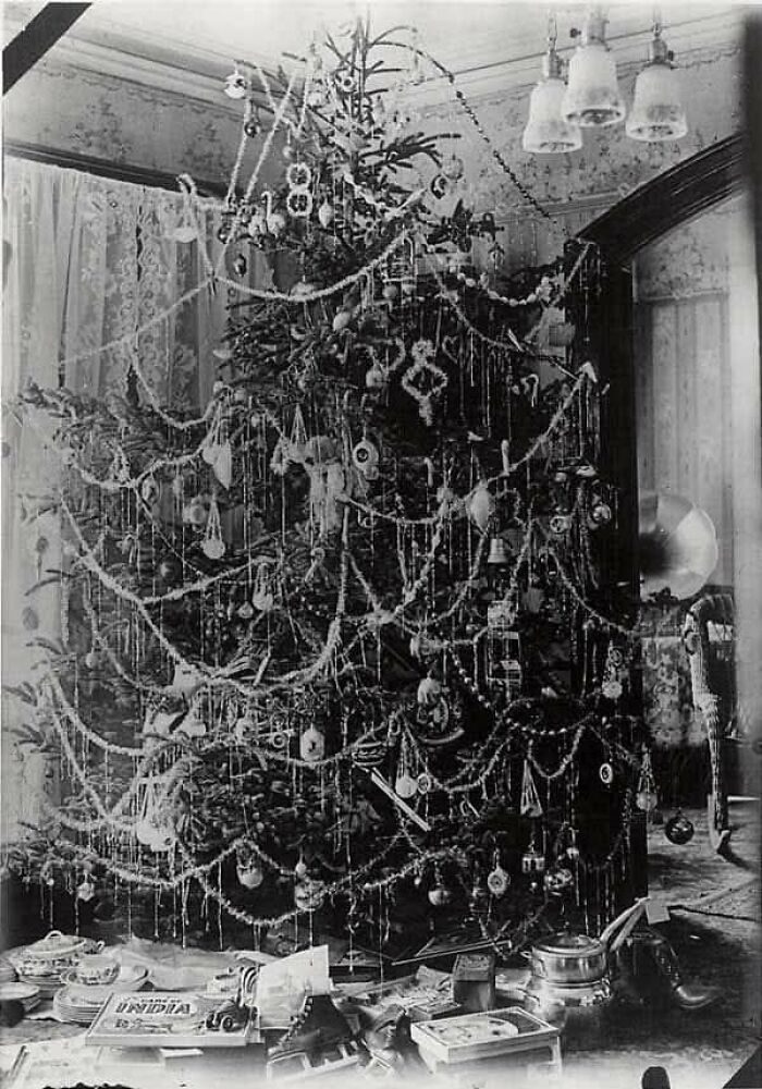 Vintage Christmas tree heavily decorated with ornaments and garlands, capturing culture and everyday life from the past.