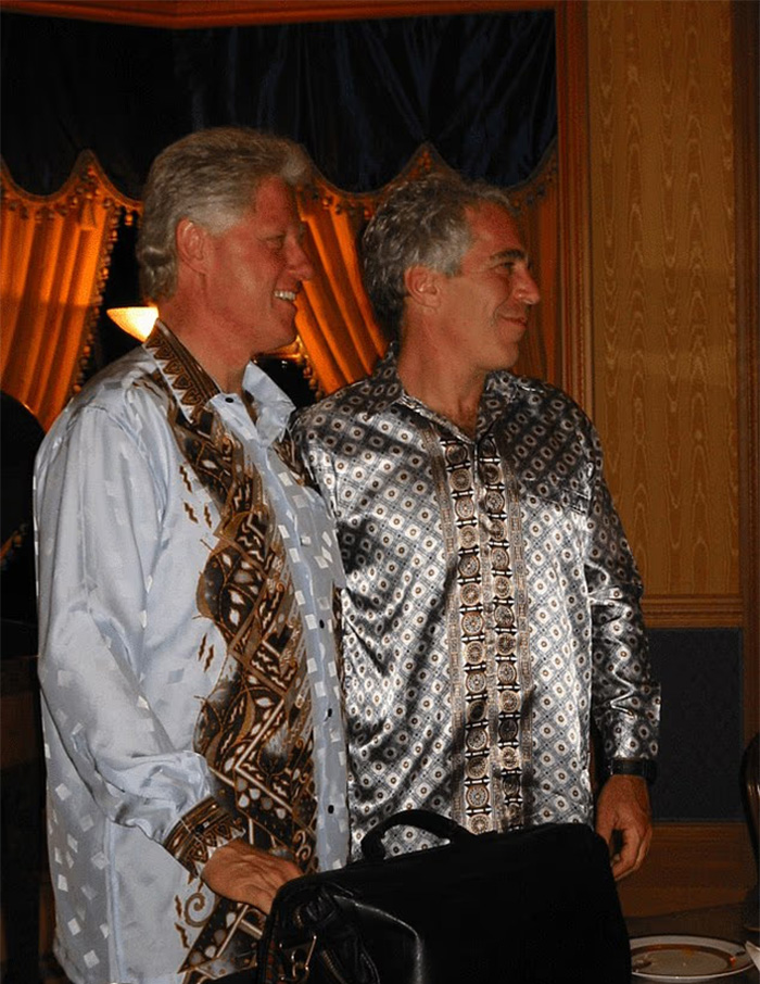 Two men in patterned shirts standing side by side, with a chilling toddler's foot appearing beside Epstein in photo.