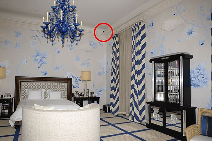 Bedroom interior with blue chandelier and striped curtains, highlighting chilling toddler's foot detail beside Epstein photo files.