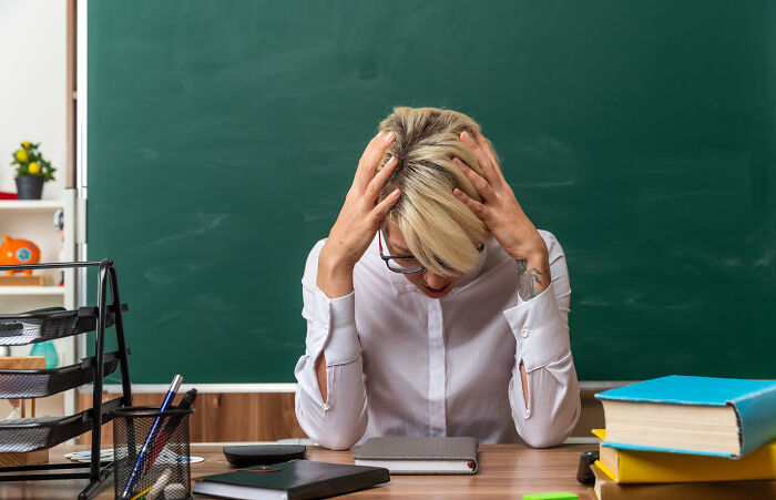 Frustrated person sitting at a desk with books and notebooks, reflecting on revenge stories with bitter aftertaste.
