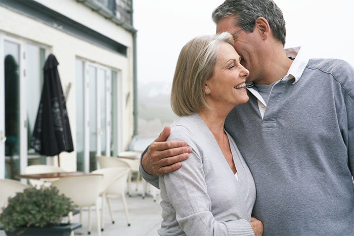 Middle-aged man and woman embracing outdoors, reflecting on relationship challenges and career honesty pressure.