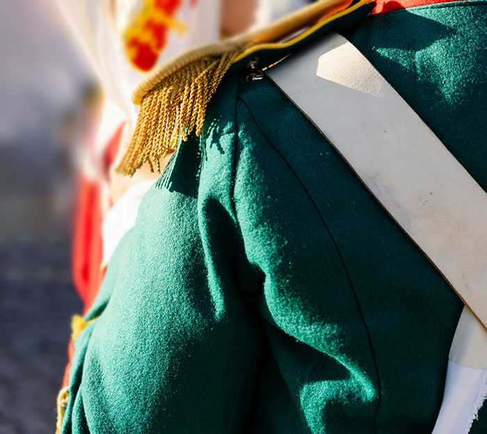 Close-up of a person in a green uniform with gold fringe, highlighting details people start to question if they really saw.