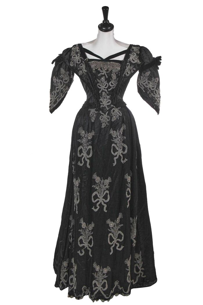 Black vintage dress with silver embroidery, capturing culture and style in powerful old photos of everyday life in the past.