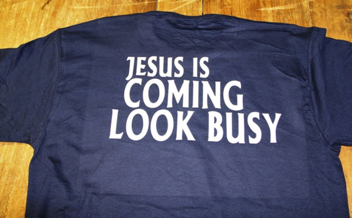Navy blue shirt with funny white text humorously warning to look busy, a popular white elephant gift idea.