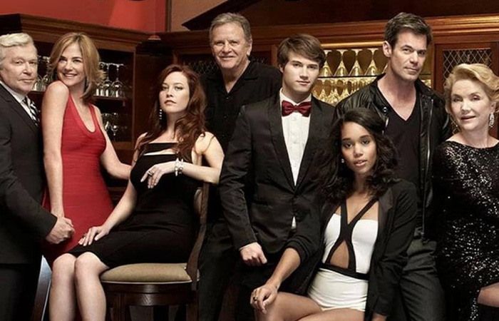 Cast of a popular long-running TV show posing together in a formal setting, highlighting the longest running TV shows.