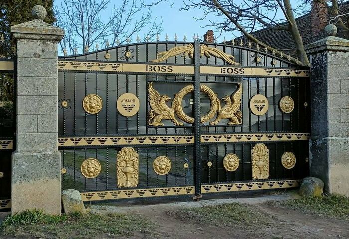 Black and gold ornate gate with boss and Armani logos, reflecting Eastern Europe humor and style in memes and pics.